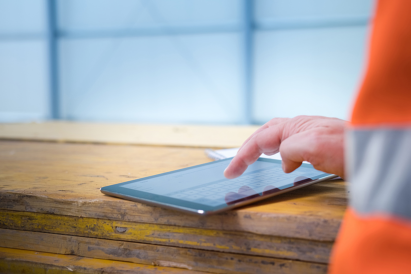 Bauarbeiter nutzt ein Tablet bei der Arbeit.