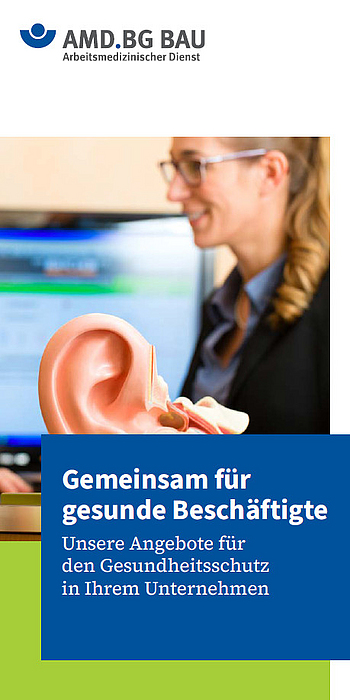 Titelbild des AMD-Imageflyers: Eine Arbeitsmedizinerin betrachtet ein großes Ohrmodell am Schreibtisch.