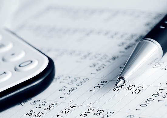 Taschenrechner und Kugelschreiber liegen auf einem Schreibtisch mit einer Liste mit Zahlen. Berechnung, Abrechnung, Finanzen, Geld