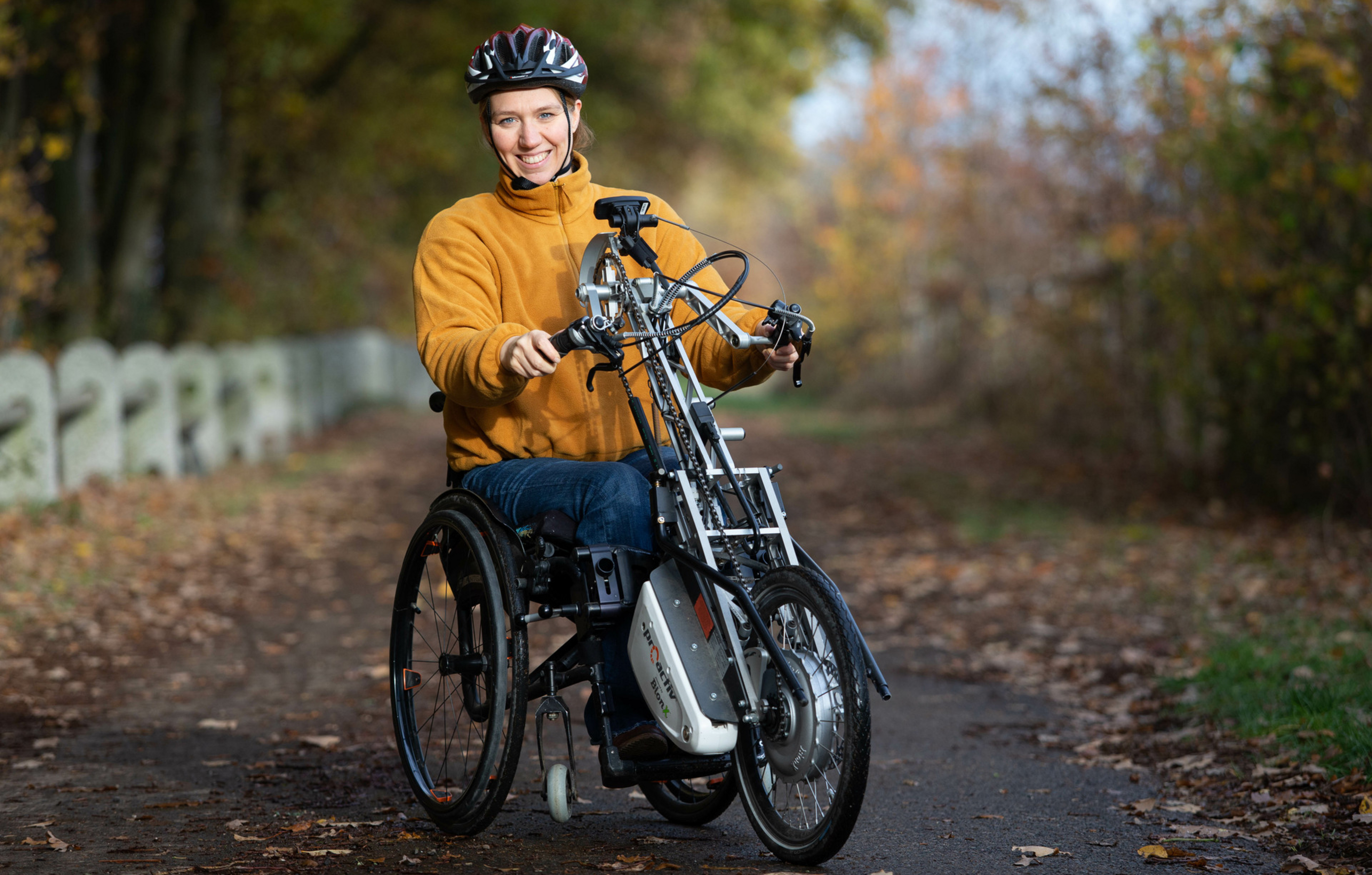Eine querschnittsgel&auml;hmte Frau f&auml;hrt mit einem Handbike. 
