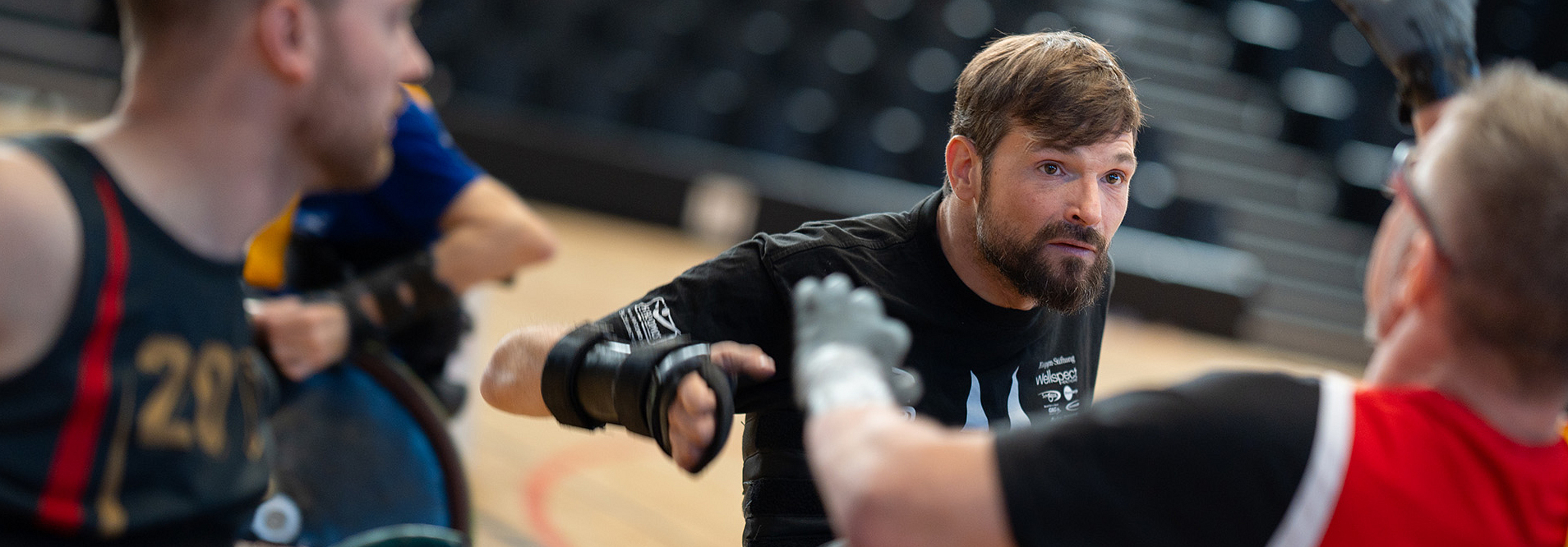 Versicherter Tobias Krämer beim Rollstuhlrugby spielen in einer Sporthalle.