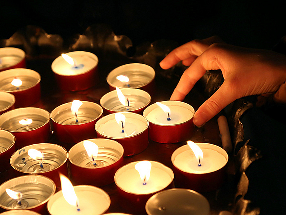 Ein Kind zündet während einer religiösen Zeremonie eine Kerze an.