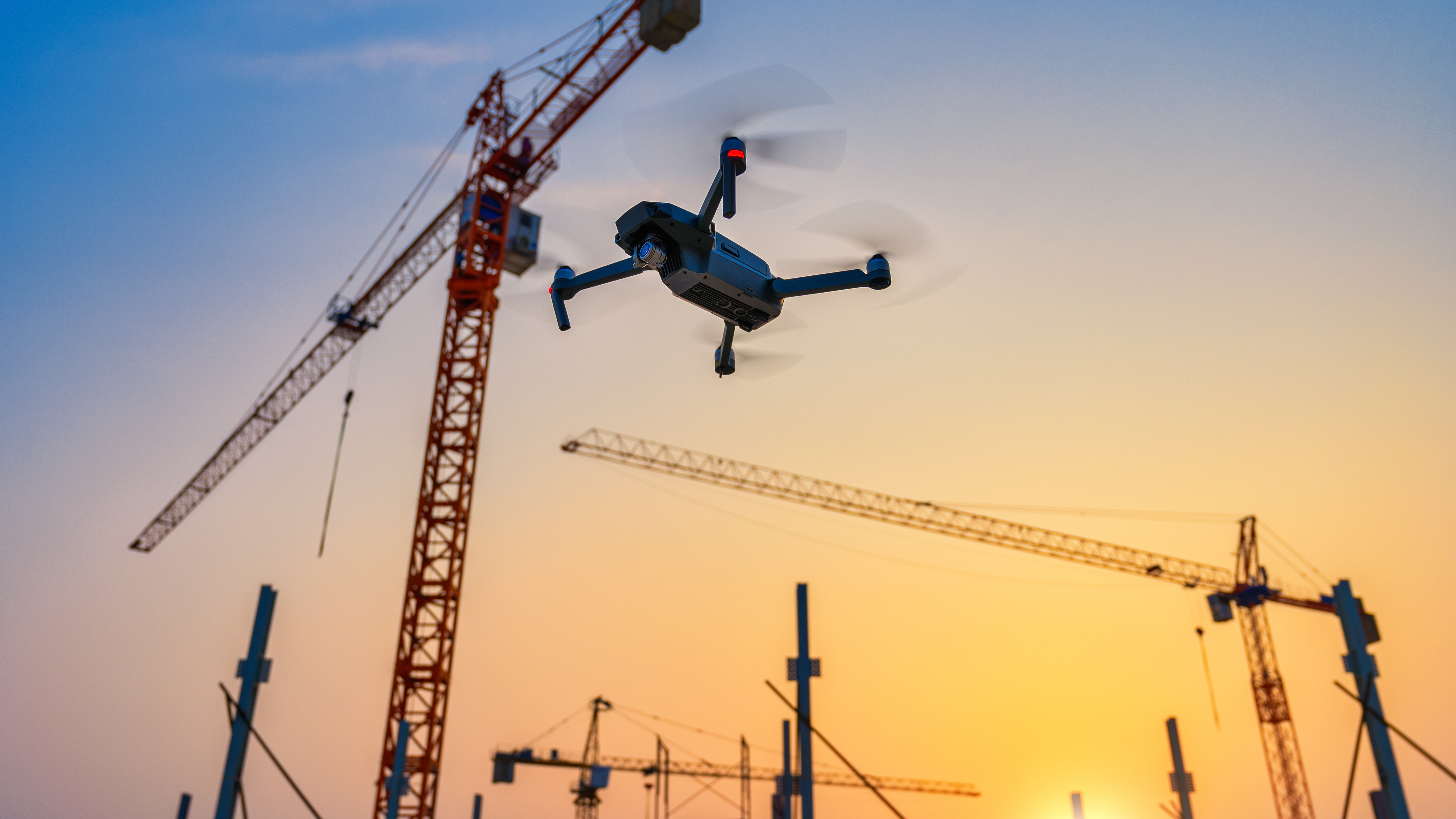 Eine Drohne fliegt &uuml;ber einer Baustelle.