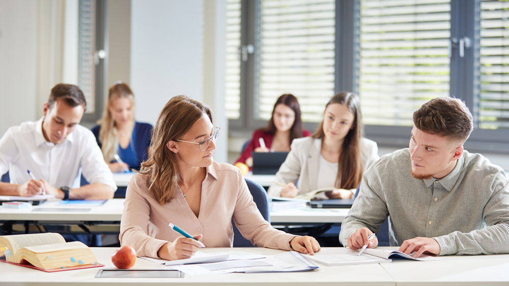 Junge Menschen lösen Aufgaben während eines Seminars.