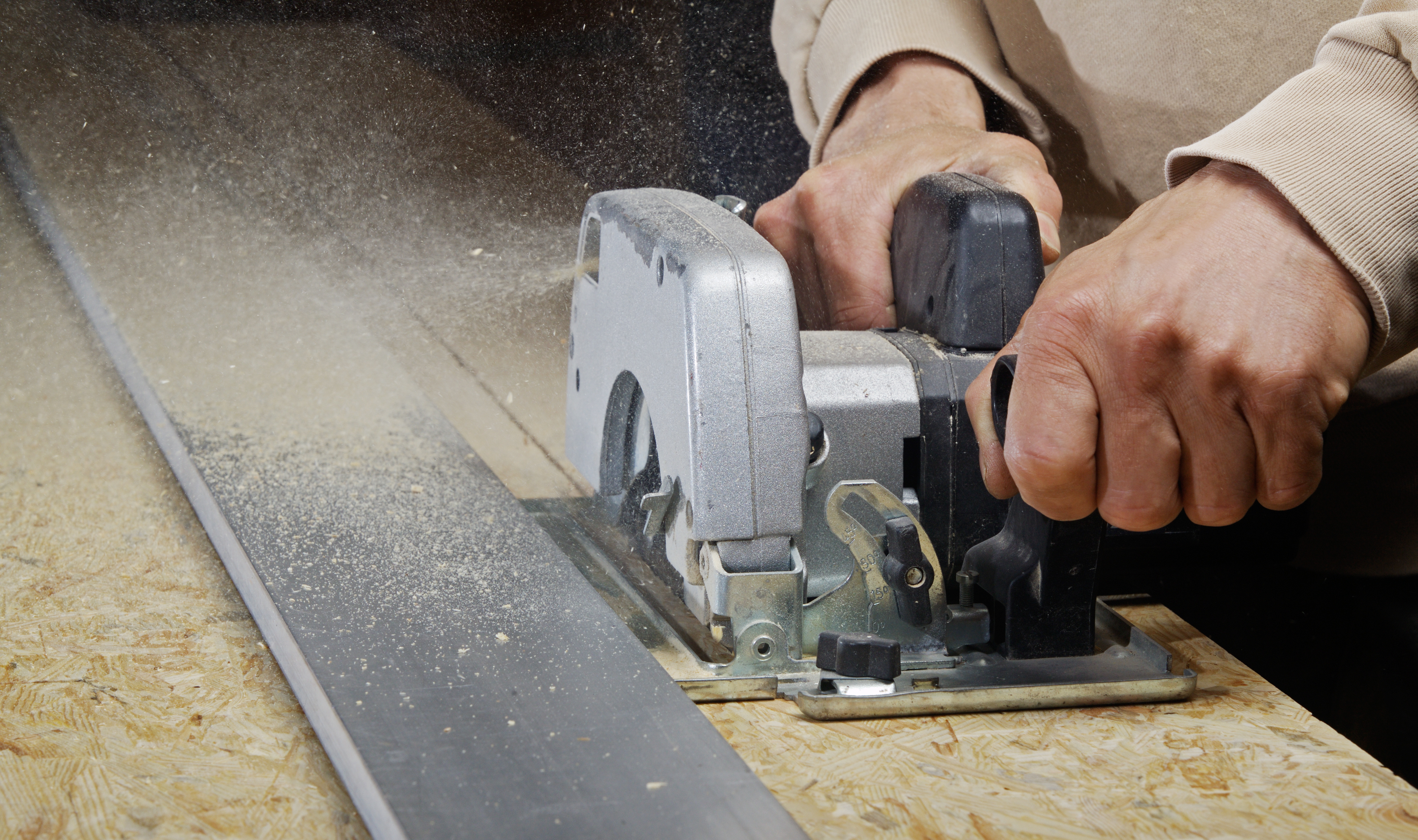 Ein Mann sägt mit einer Handkreissäge.
