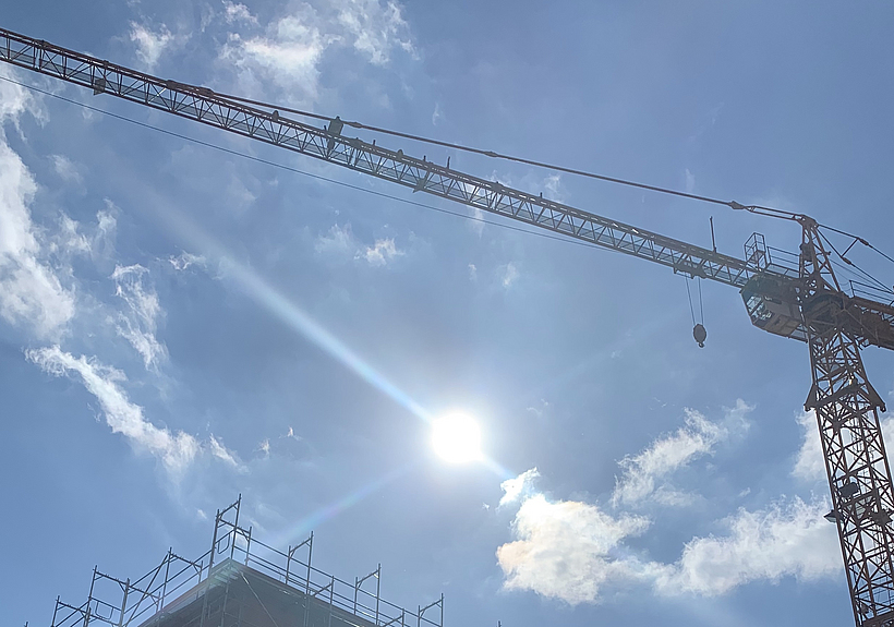 Über einer Baustelle scheint die Sonne.