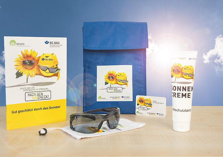 Zusammenstellung des UV-Schutz-Pakets: Sonnencreme, Sonnenbrille mit Beutel, UV-Check-Karte und Informationsmaterial zum UV-Schutz