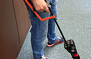 Eine Person bedient einen Bewehrungsstahlschneider mit Armstütze, um auf dem Boden liegenden Bewehrungsstahl zu schneiden.