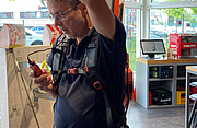 Eine Person trägt ein körpergetragenes Stützsystem und hält ein Werkzeug in der Hand, während das System über ihr angebracht ist und das Gewicht abfängt.