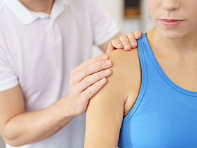 Eine Physiotherapeutin behandelt eine Patientin an der Schulter.