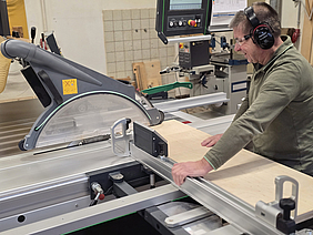 Ein Tischler arbeitet mit einer Tischkreissäge.