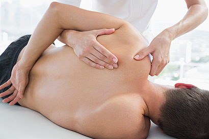 Ein Patient ist bei der Physiotherapie und lässt seine Schulterschmerzen behandeln.