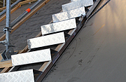 Eine Stufen-Auflegeleiter liegt auf einem Dach. Sie erleichtert den Zugang und die Durchführung von Dacharbeiten.