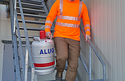 Beim Treppenabsteigen trägt ein Mann eine Gasflasche herunter