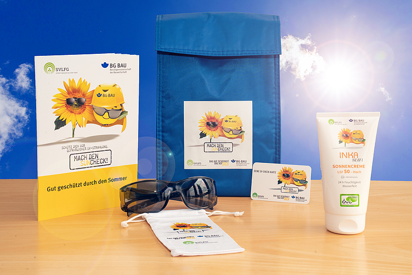 Zusammenstellung des UV-Schutz-Pakets: Sonnencreme, Sonnenbrille mit Beutel, UV-Check-Karte und Informationsmaterial zum UV-Schutz