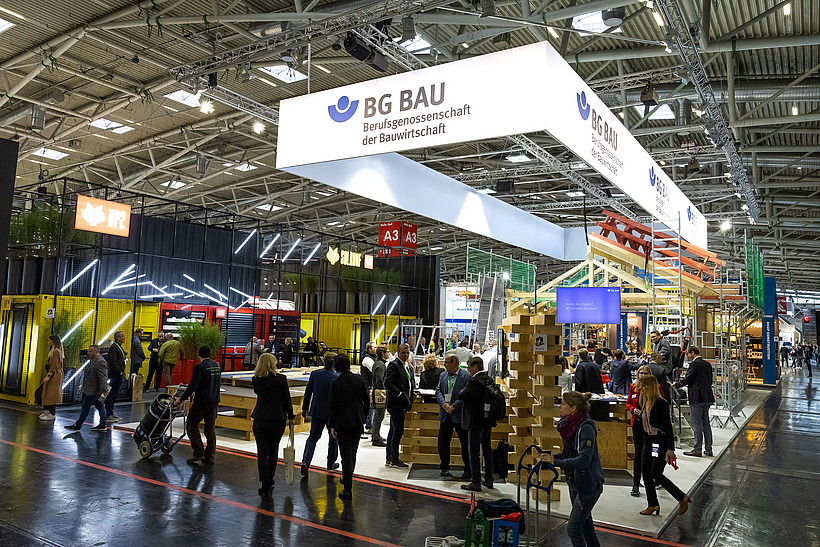 Der Stand der BG BAU auf der Messe BAU 2023 mit vielen Messebesuchern.