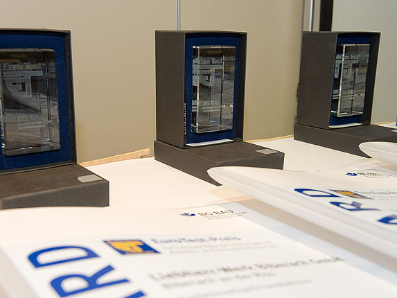 Auf einem Tisch stehen die EuroTest-Preise mit den Auszeichnungen.