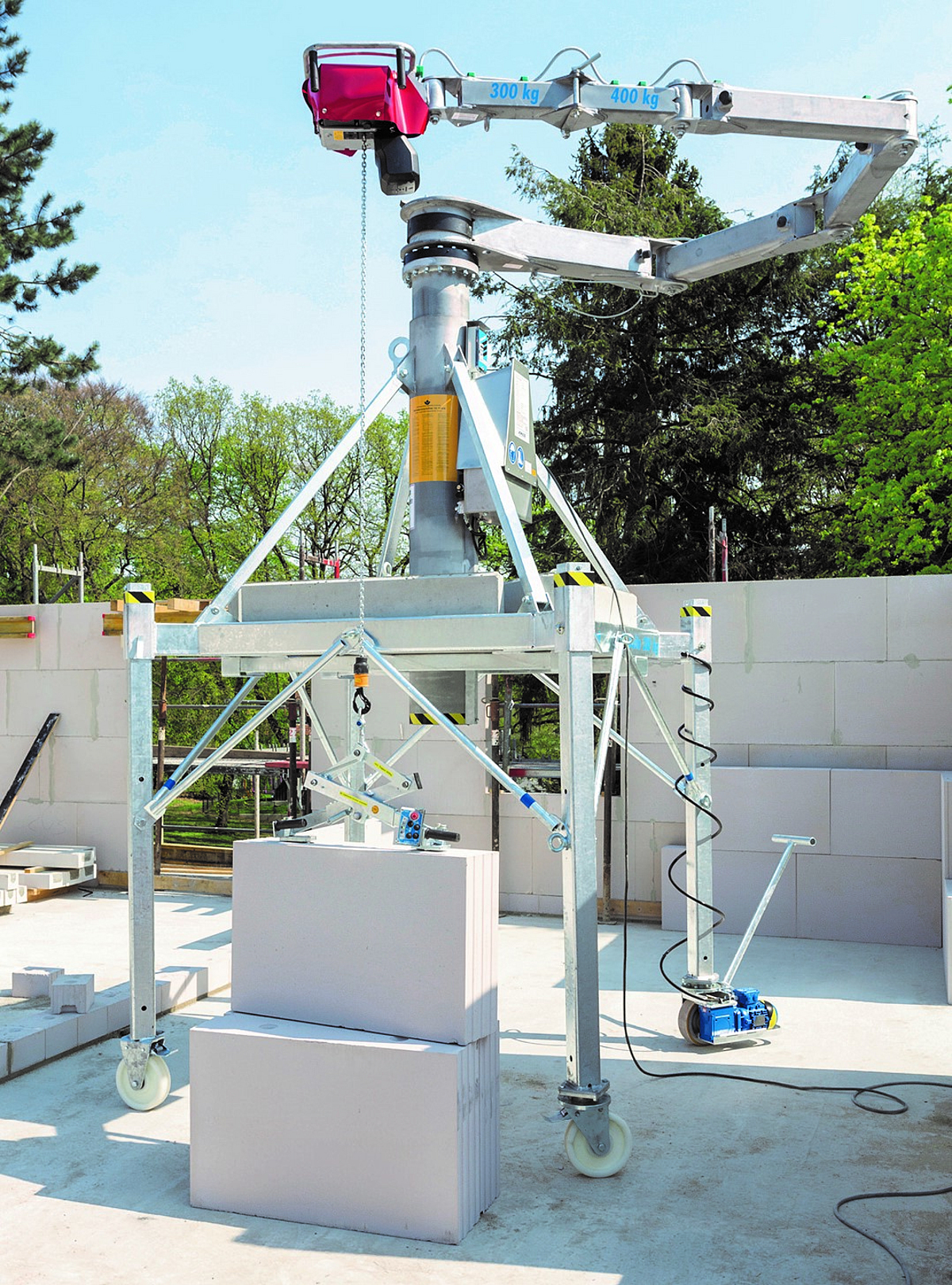 Ein Minikran steht auf einer Baustelle innerhalb eines Gebäudes, das gerade gebaut wird.