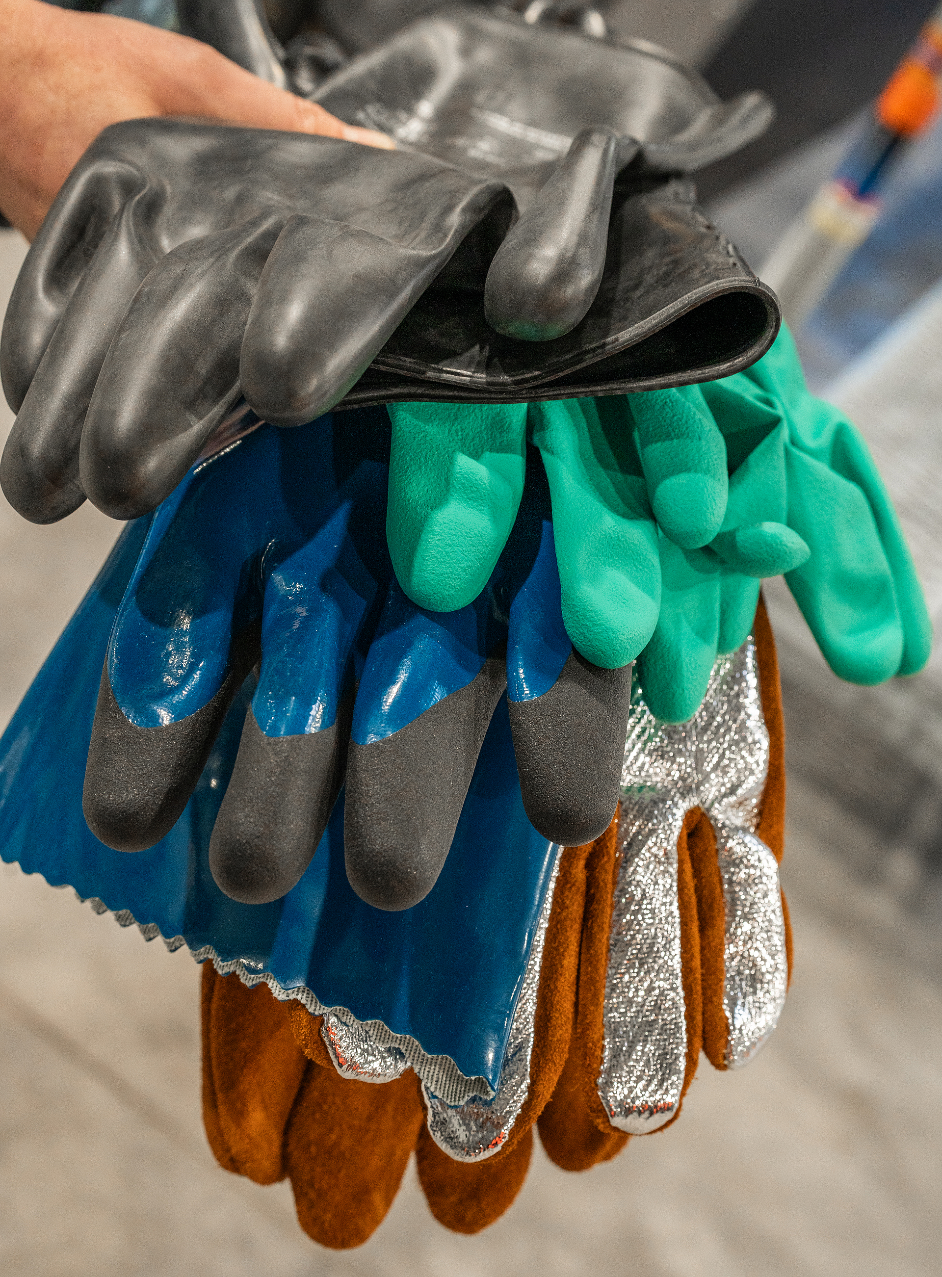 Vier verschiedene Typen von Chemikalienschutzhandschuhe liegen übereinander.
