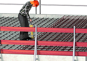 Ein Bauarbeiter auf einem Dach eines Gebäudes mit temporärem Seitenschutzsystem