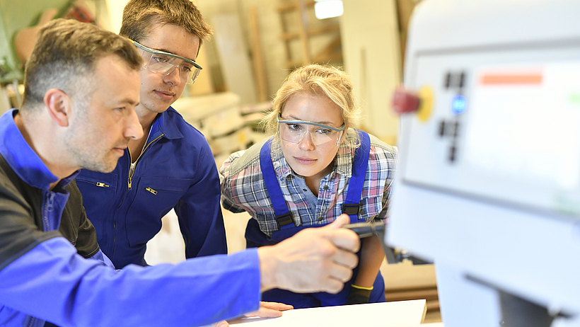 Lehrer erkl&auml;rt Sch&uuml;lern einen Arbeitsschritt.