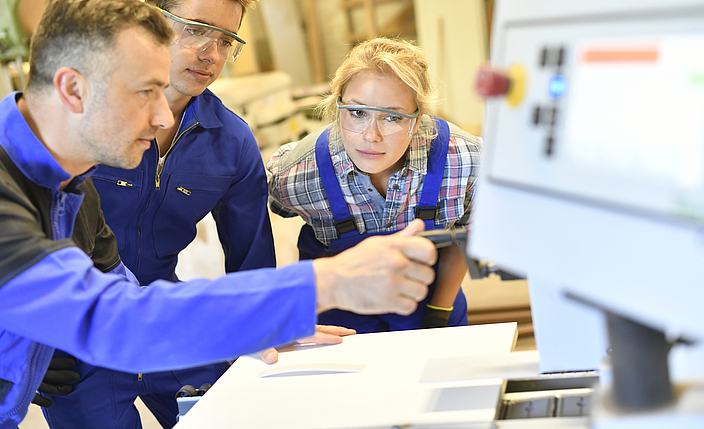 Lehrer erklärt Schülern einen Arbeitsschritt.