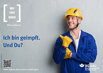 Ein junger Mann mit Schutzhelm und Handschuhen zeigt mit seiner erhobenen Hand bzw. Daumen in eine Richtung.
