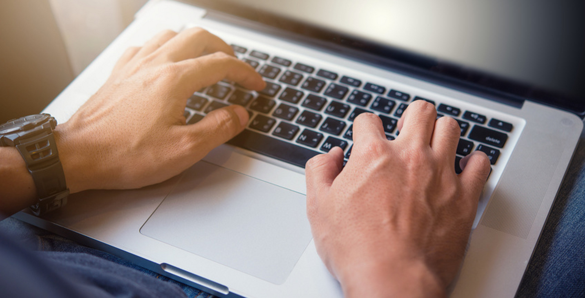 Hände schreiben auf einem Laptop. 