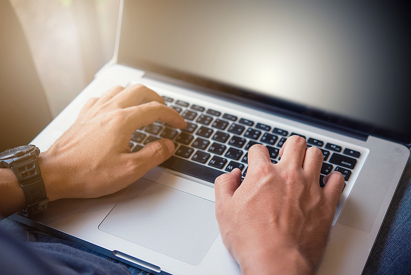 H&auml;nde schreiben auf einem Laptop. 