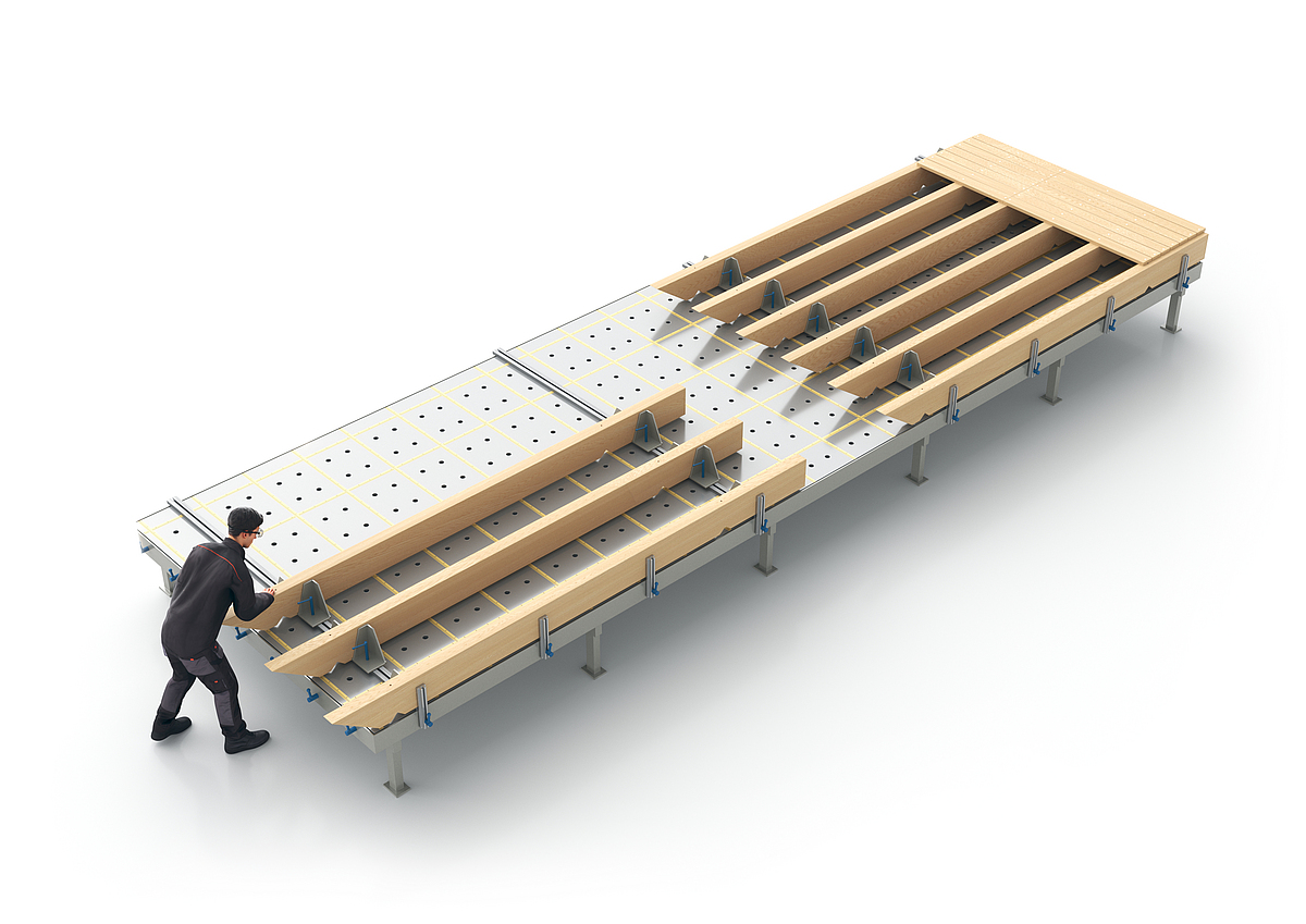 Auf einem Montagetisch wird ein Wanddecken- oder Dachelement aus Holz von einer Person vorgefertigt.