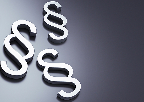 Mehrere Paragraphen liegen als Symbole auf einem Haufen.