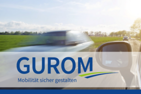 GUROM Logo auf dem Foto einer stark befahrenen Landstraße.