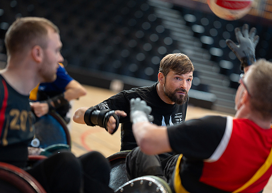 Versicherter Tobias Krämer beim Rollstuhlrugby spielen in einer Sporthalle.