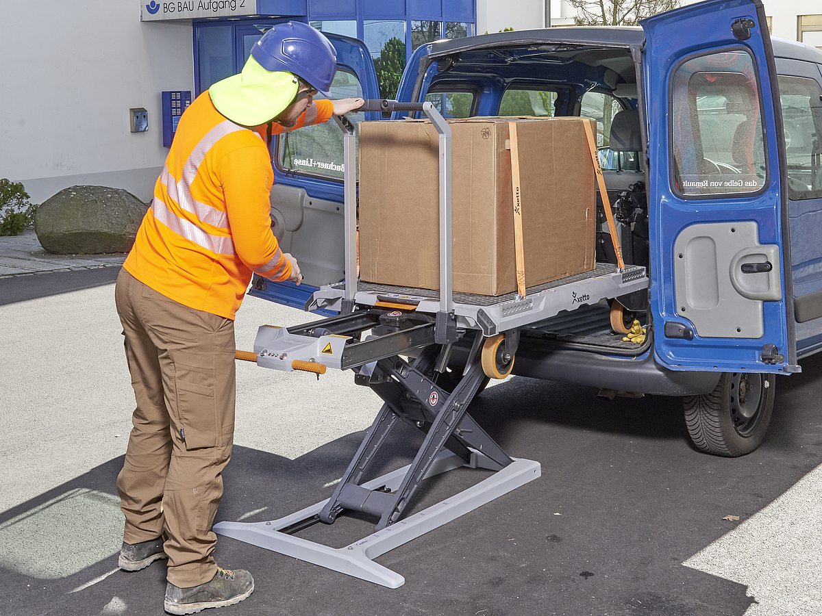 Ein Mann nutzt das integrierte elektrohydraulische System des Transportwagens mit Hebehilfe (xetto)