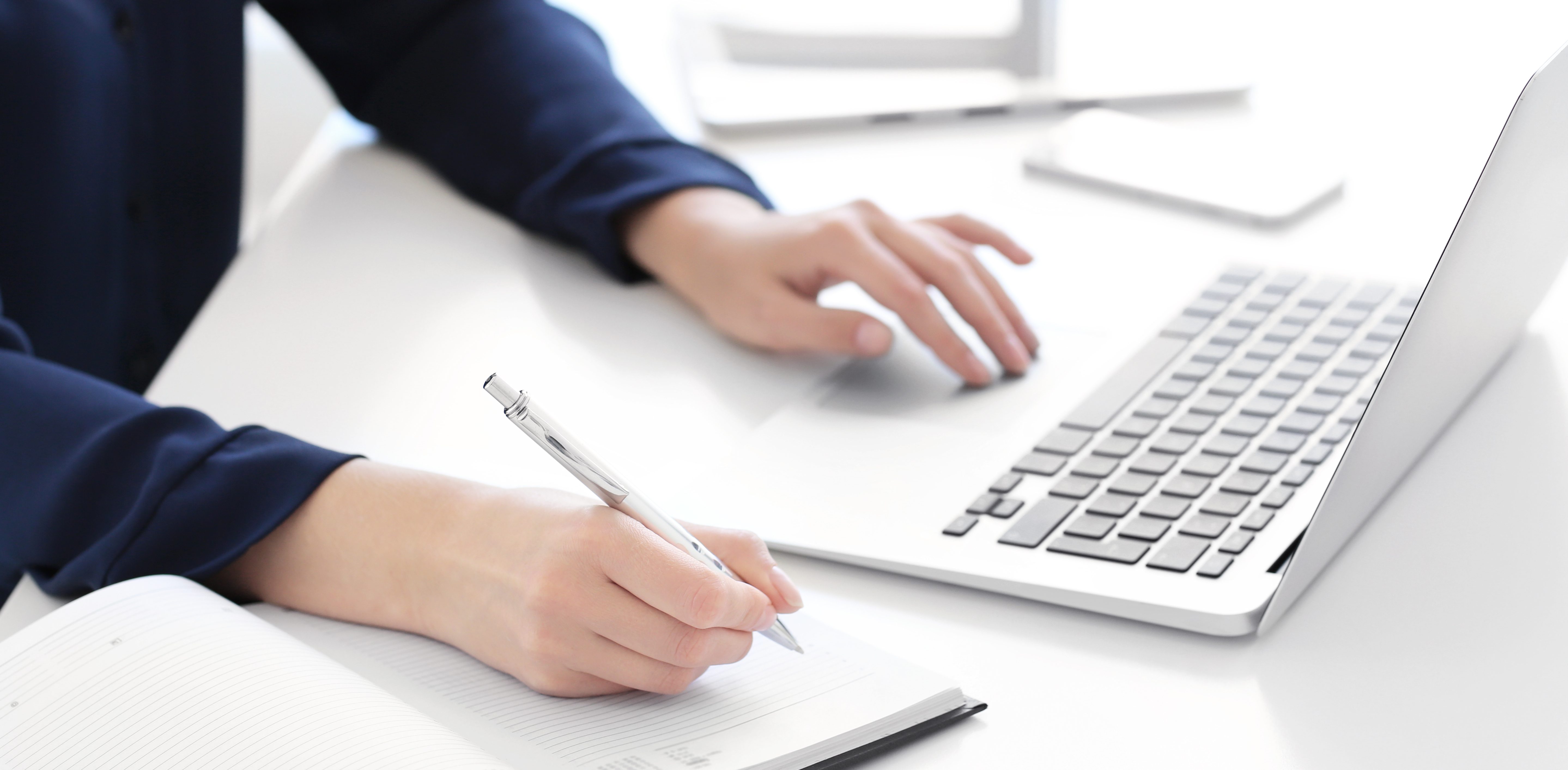 Junge Frau, die am Schreibtisch einen Laptop für die Suche von Informationen im Internet verwendet