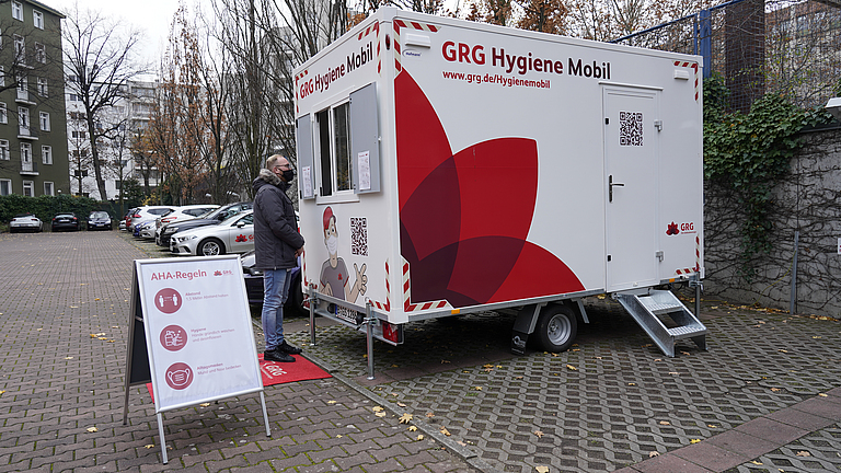 Mann steht vor GRG-Hygienemobil, einer mobilen Corona-Teststation