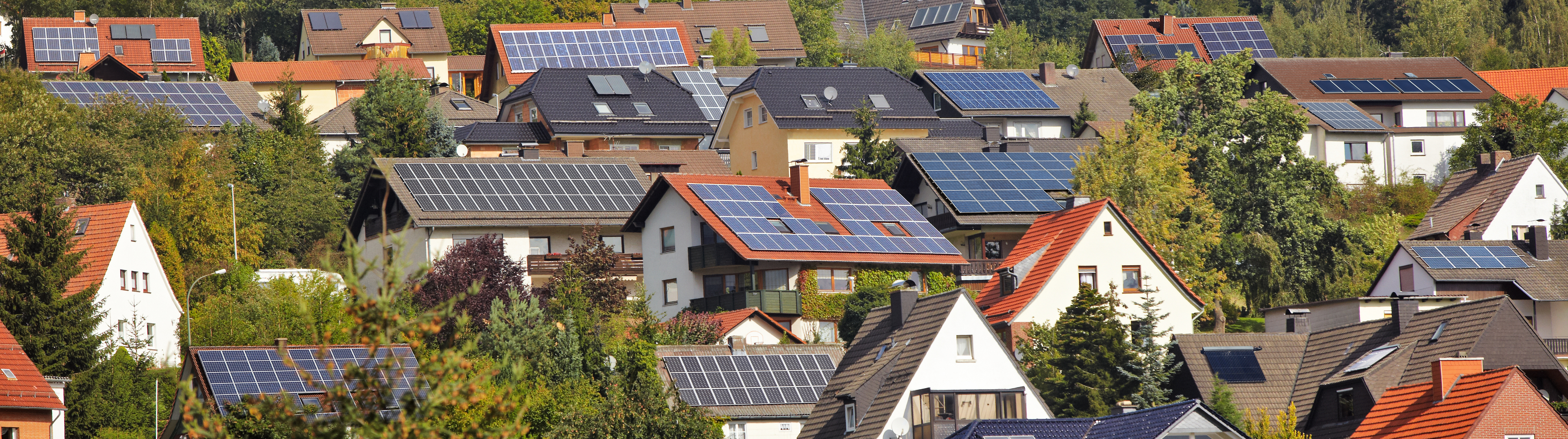 Blick auf viele H&auml;user mit PV-Anlagen.