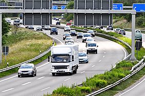 Autobahn mit fließendem Verkehr, LKW ist im Vordergrund.